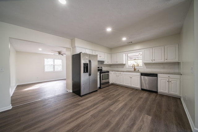 kitchen with white cabinetry, sink, decorative backsplash, stainless steel appliances, and dark wood-type flooring