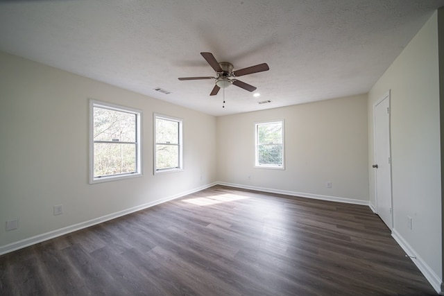 empty room featuring ceiling fan, dark hardwood / wood-style floors, and a textured ceiling