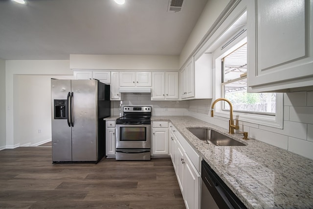 kitchen with sink, dark hardwood / wood-style floors, stainless steel appliances, light stone countertops, and white cabinets