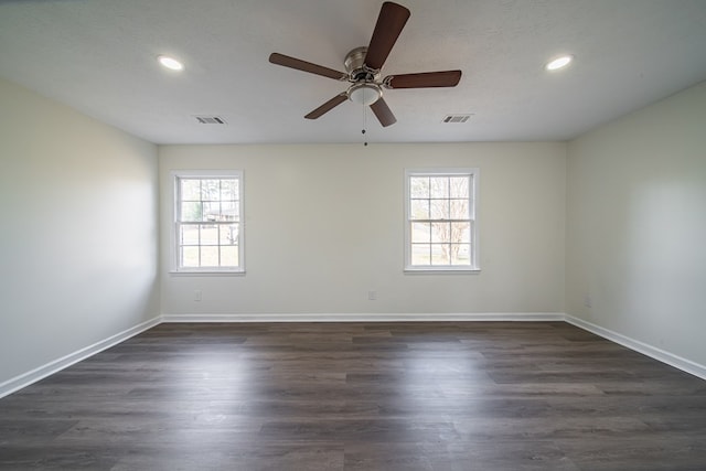 unfurnished room with ceiling fan, a wealth of natural light, dark hardwood / wood-style floors, and a textured ceiling