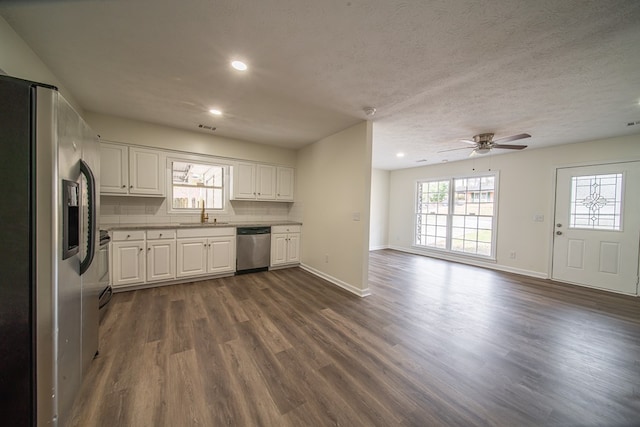 kitchen featuring tasteful backsplash, appliances with stainless steel finishes, white cabinets, and dark hardwood / wood-style flooring