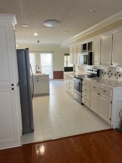 kitchen with black fridge, crown molding, light wood-type flooring, electric stove, and white cabinets