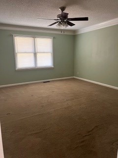 carpeted spare room featuring ornamental molding, ceiling fan, and a textured ceiling