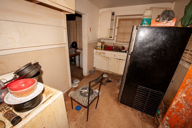 kitchen featuring white cabinets and freestanding refrigerator