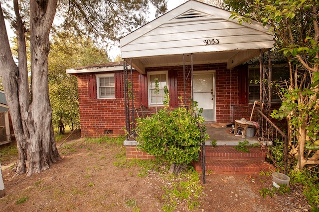 view of front of home with covered porch and brick siding