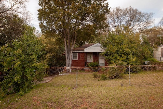 view of front facade with a front yard, brick siding, and fence private yard