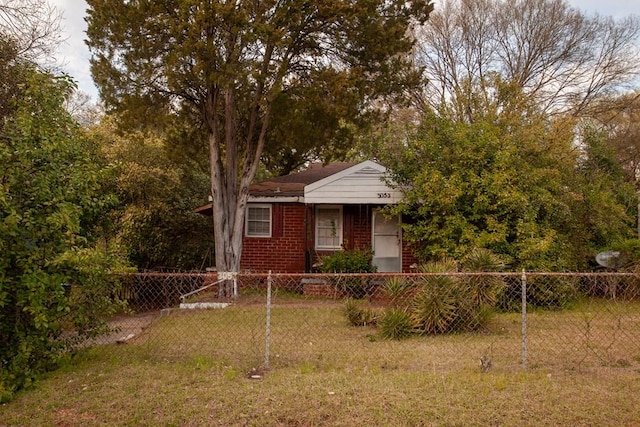 view of front of house with brick siding, a front lawn, and fence