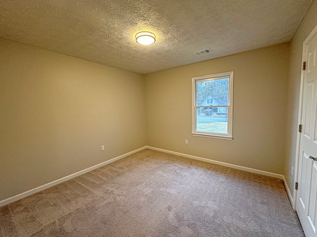 carpeted empty room featuring a textured ceiling