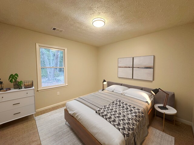 bedroom featuring carpet flooring and a textured ceiling