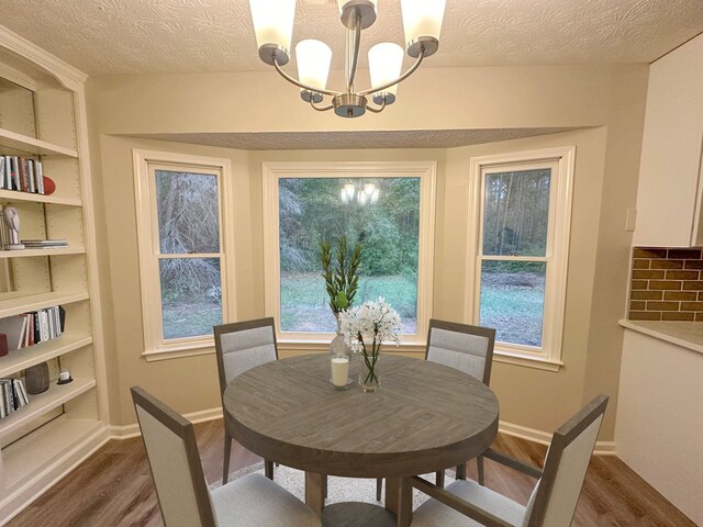 dining room featuring a textured ceiling, dark hardwood / wood-style floors, and a notable chandelier