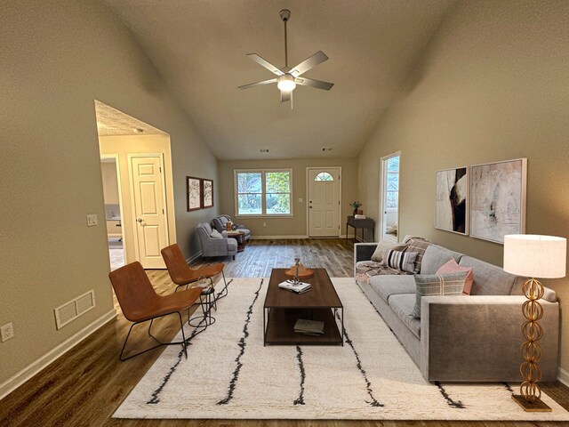 living room with hardwood / wood-style flooring, ceiling fan, and high vaulted ceiling