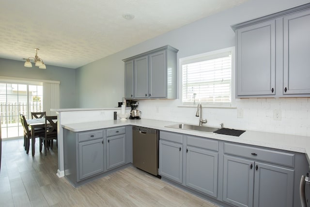 6074 White Pine Dr, Midland, GA 31820 - kitchen with stainless steel dishwasher, gray cabinets, a peninsula, decorative backsplash, and a textured ceiling