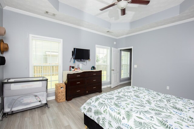 6074 White Pine Dr, Midland, GA 31820 - bedroom with a raised ceiling, light wood-style flooring, crown molding, and a ceiling fan