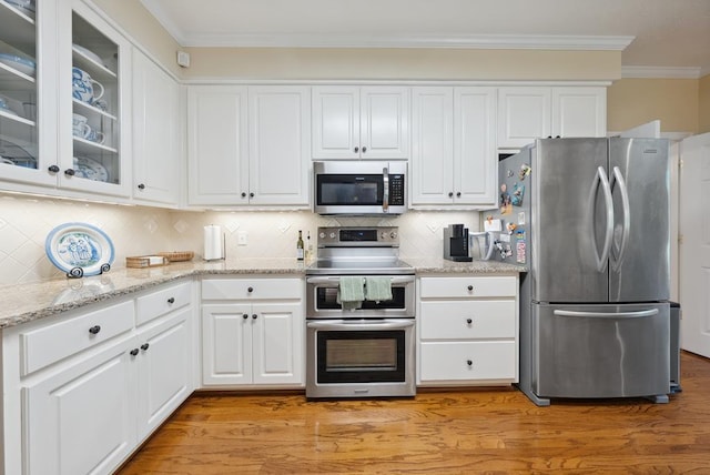 9011 Travelers Way, Midland, GA 31820 - kitchen featuring appliances with stainless steel finishes, crown molding, white cabinets, light wood finished floors, and backsplash
