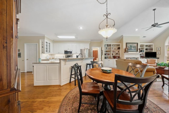 9011 Travelers Way, Midland, GA 31820 - dining room with built in shelves, light wood-type flooring, ceiling fan, lofted ceiling, and a fireplace