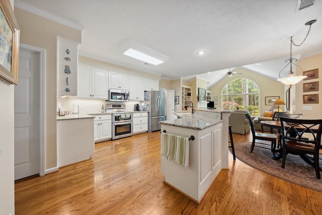 9011 Travelers Way, Midland, GA 31820 - kitchen with stainless steel appliances, ornamental molding, light wood-style floors, a kitchen breakfast bar, and white cabinetry