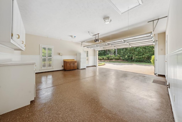 9011 Travelers Way, Midland, GA 31820 - garage with a garage door opener, wainscoting, and freestanding refrigerator