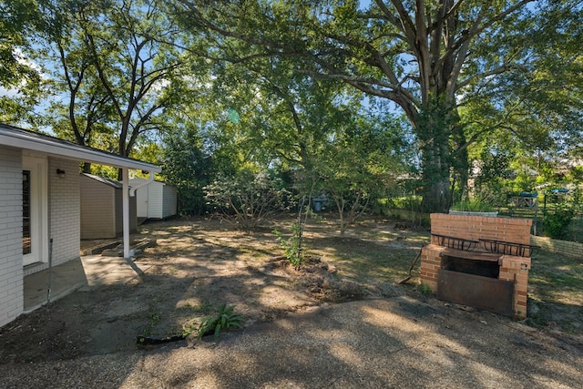 view of yard featuring fence, an outdoor structure, and a shed