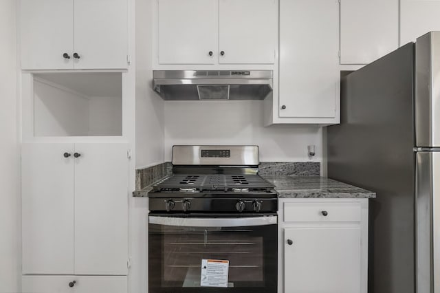 kitchen with under cabinet range hood, white cabinetry, stainless steel appliances, and dark stone counters