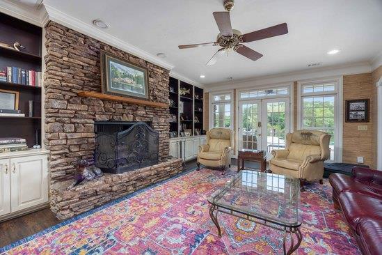 219 Broken Rock Rd, Hamilton, GA 31811 - living room with ornamental molding, a ceiling fan, a fireplace, french doors, and built in features