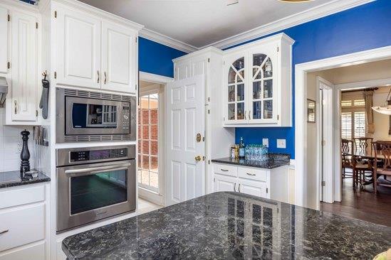 219 Broken Rock Rd, Hamilton, GA 31811 - kitchen featuring stainless steel appliances, white cabinetry, ornamental molding, glass insert cabinets, and dark stone counters
