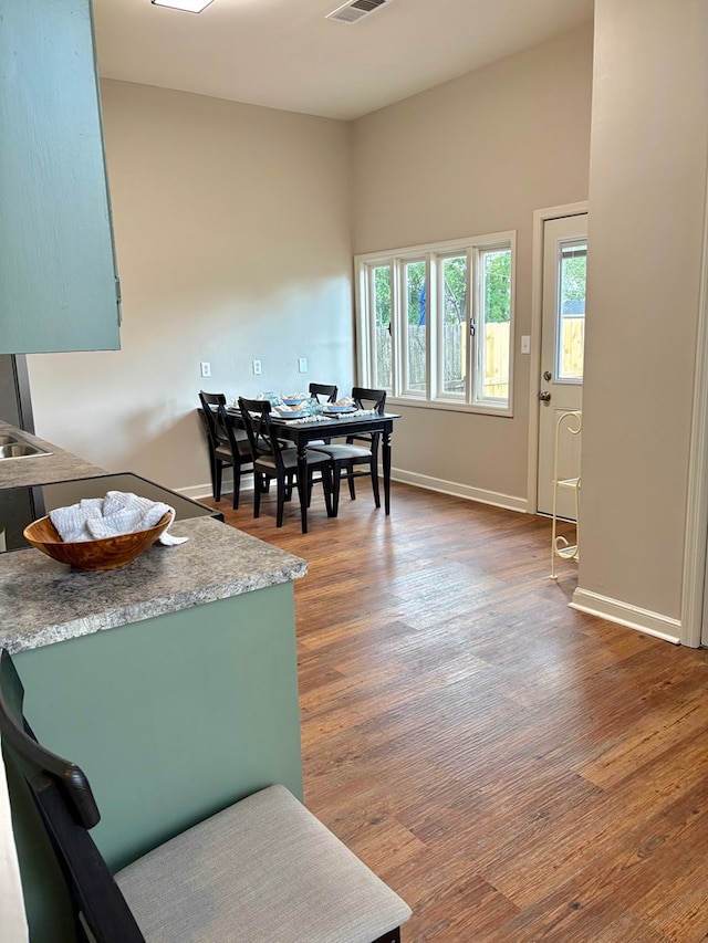 dining space featuring visible vents, wood finished floors, and baseboards