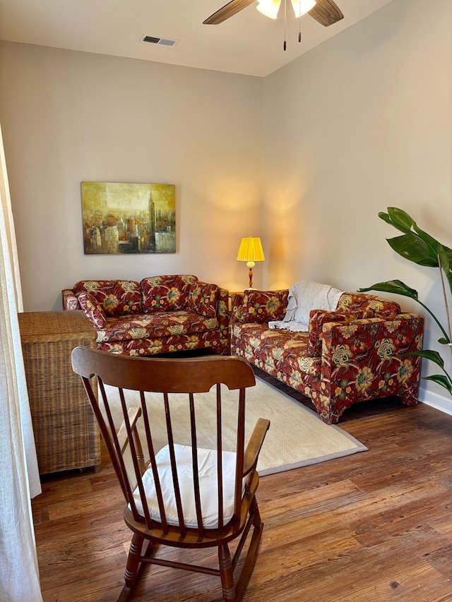 sitting room with visible vents, ceiling fan, and wood finished floors