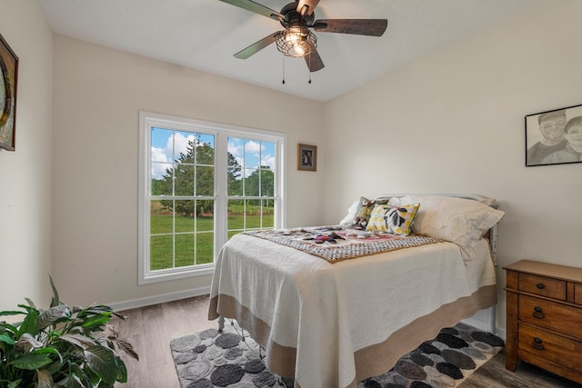 bedroom featuring baseboards, ceiling fan, and wood finished floors