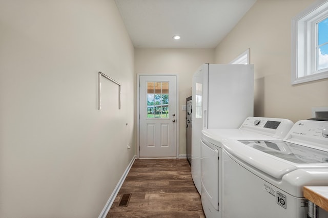 laundry area with laundry area, visible vents, washing machine and clothes dryer, baseboards, and dark wood-style floors