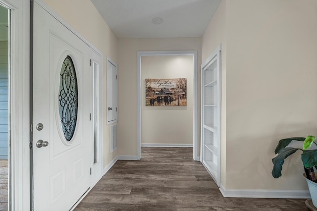 entrance foyer with baseboards, visible vents, and dark wood-type flooring