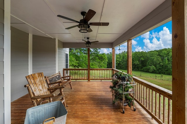deck with a ceiling fan and a yard