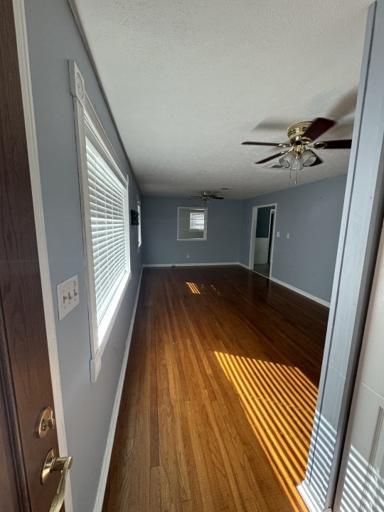 unfurnished room with a textured ceiling, hardwood / wood-style flooring, and ceiling fan