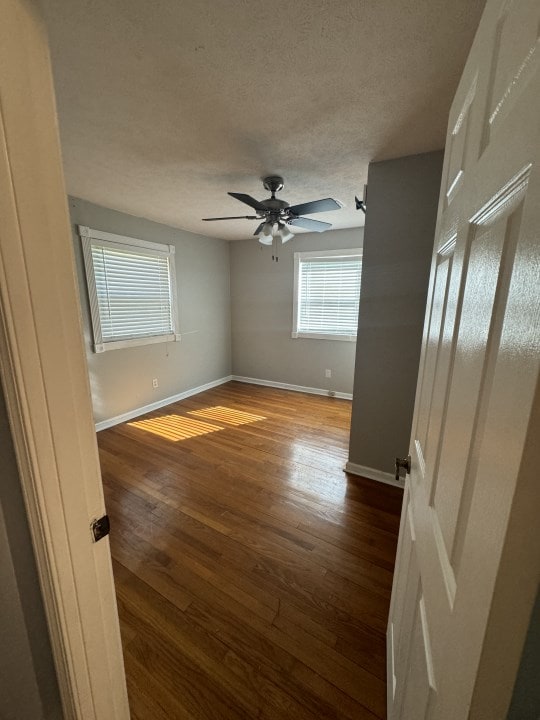 empty room featuring ceiling fan and dark hardwood / wood-style flooring