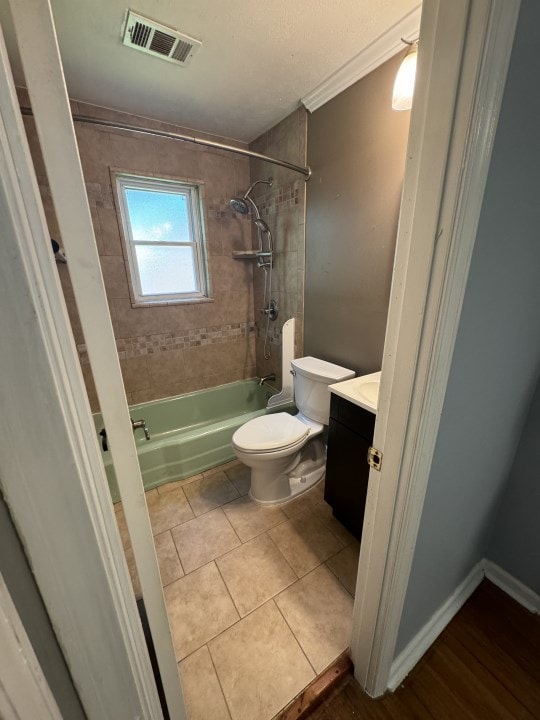 full bathroom with tile patterned flooring, vanity, toilet, and tiled shower / bath