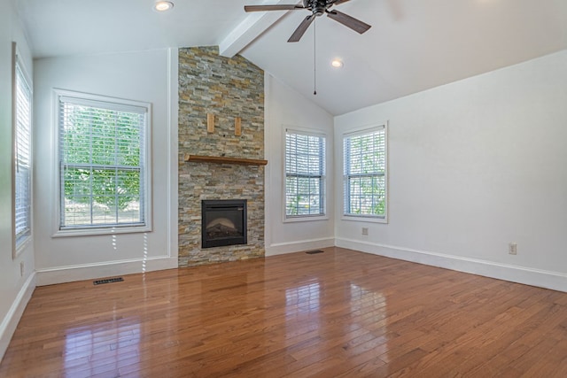 unfurnished living room featuring a wealth of natural light, visible vents, and wood finished floors