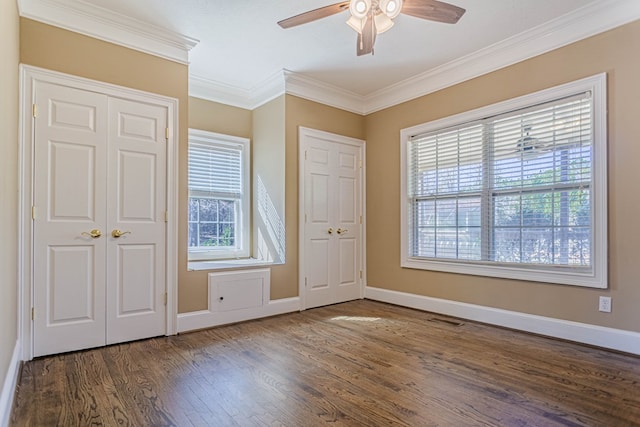 interior space with baseboards, visible vents, dark wood-style floors, and ornamental molding