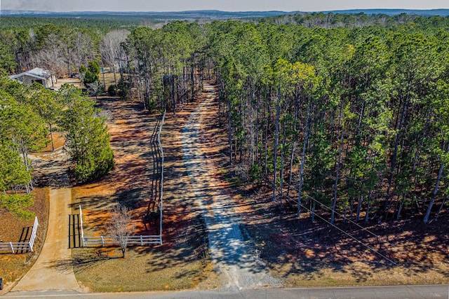 aerial view featuring a wooded view and a rural view