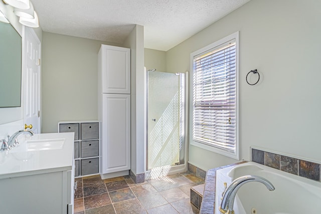 bathroom with a sink, a whirlpool tub, a shower stall, double vanity, and stone tile floors