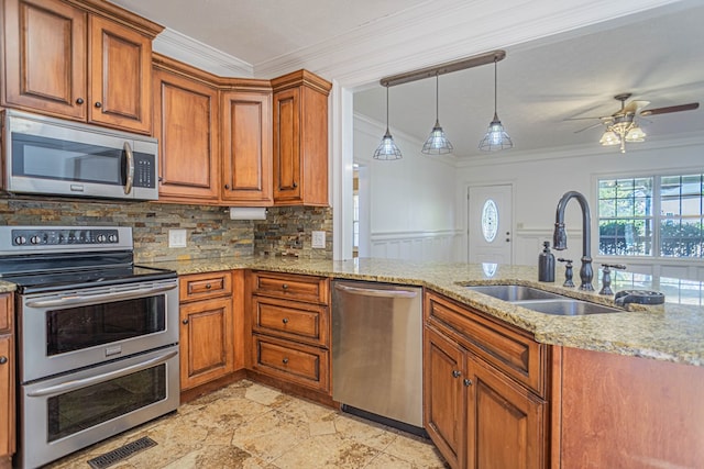 kitchen featuring crown molding, pendant lighting, a sink, and appliances with stainless steel finishes