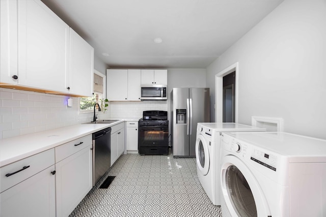 956 Lake Rushin Dr, Columbus, GA 31907 - kitchen with appliances with stainless steel finishes, tasteful backsplash, white cabinetry, and independent washer and dryer
