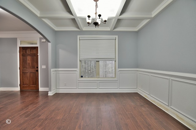 spare room with beamed ceiling, dark hardwood / wood-style floors, an inviting chandelier, and coffered ceiling