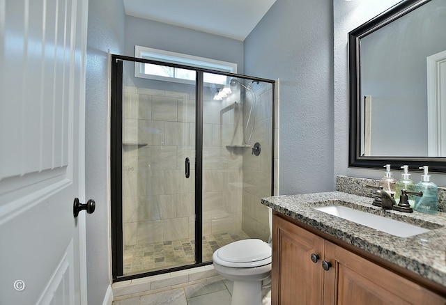 bathroom with vanity, toilet, and a shower with door