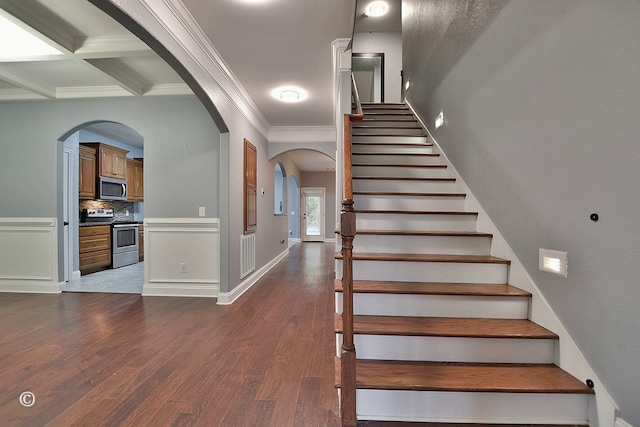 staircase with beamed ceiling, hardwood / wood-style floors, crown molding, and coffered ceiling