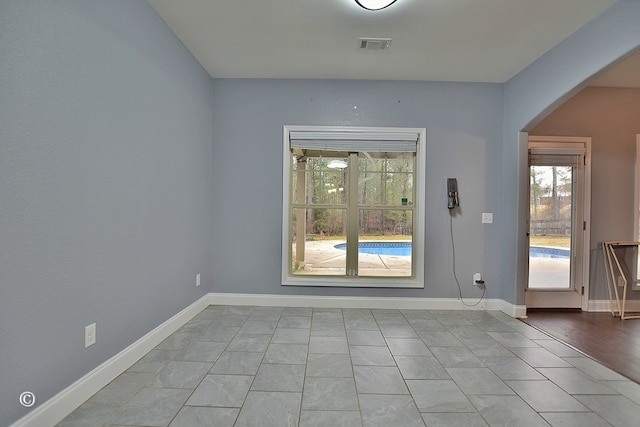 spare room featuring plenty of natural light and light tile patterned flooring