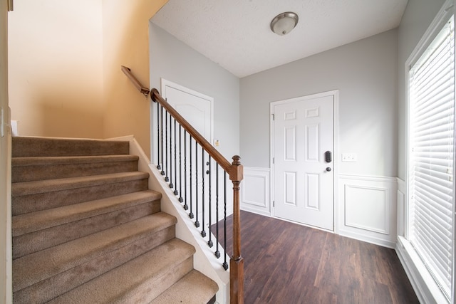 foyer entrance featuring dark hardwood / wood-style floors and a textured ceiling