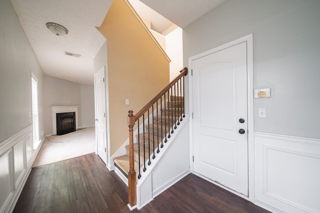 foyer featuring dark hardwood / wood-style floors and a textured ceiling