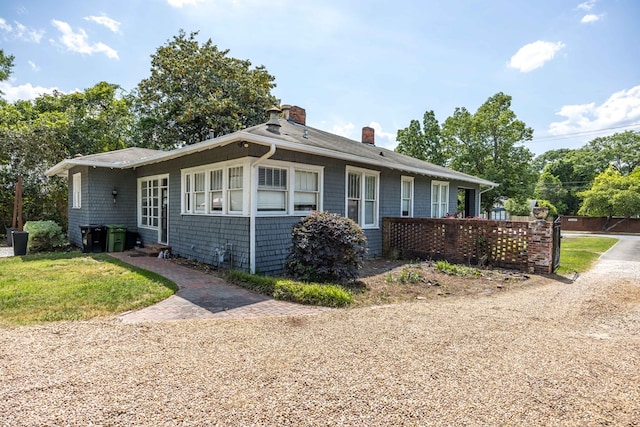 single story home featuring a front lawn, fence, a chimney, and entry steps