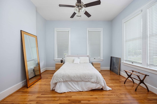 bedroom featuring baseboards, ceiling fan, and light wood finished floors