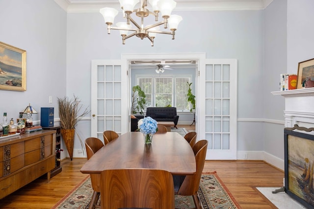dining area featuring baseboards, a fireplace with flush hearth, ornamental molding, and wood finished floors