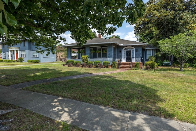 ranch-style home featuring a chimney and a front lawn